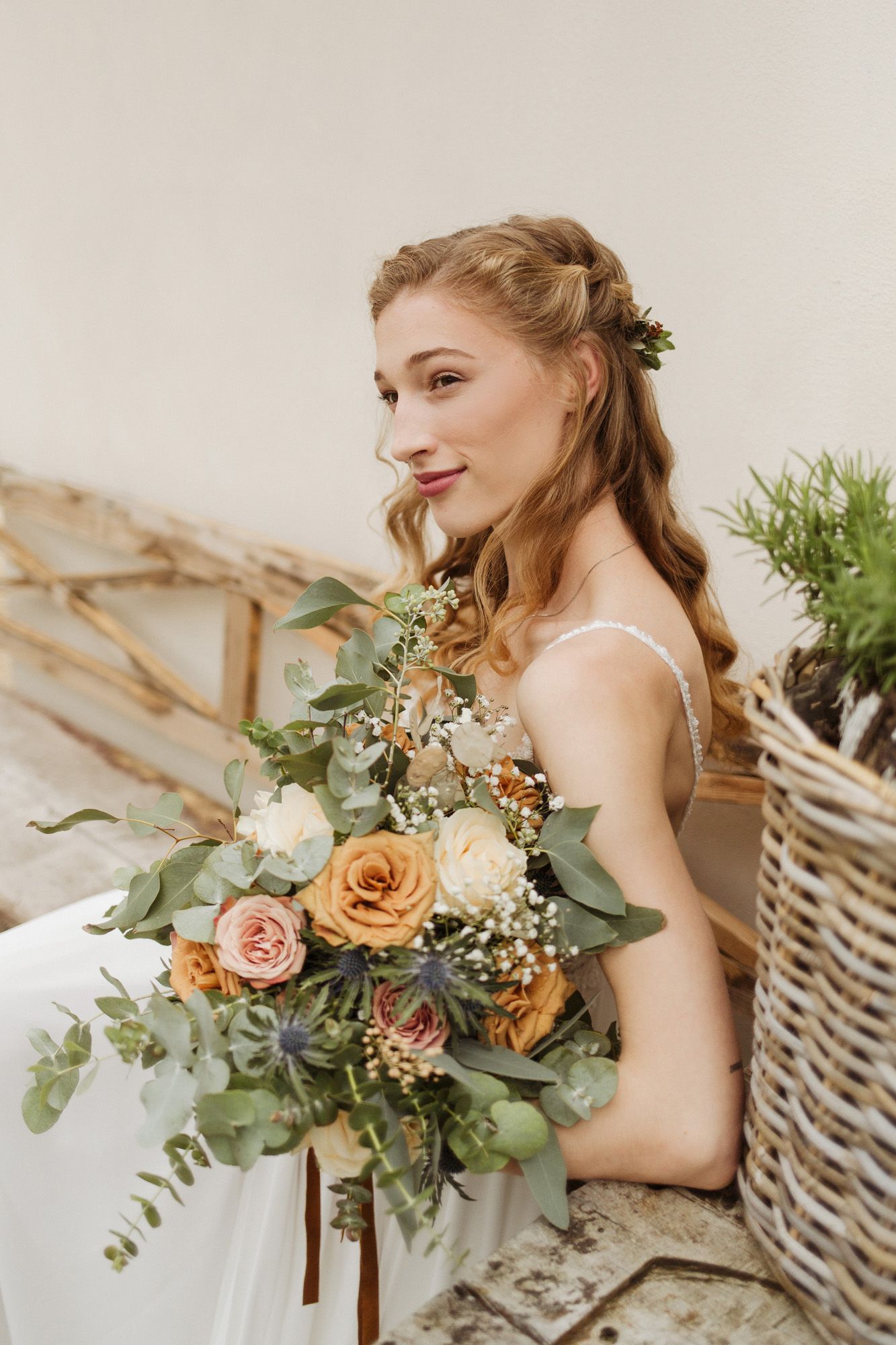 Elegant bridal portrait with peach and cream floral bouquet against neutral background.