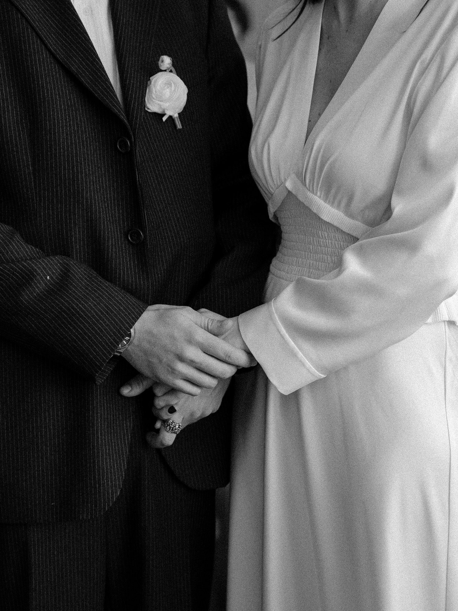 Close-up of bride and groom in formal attire showing subtle wedding day details.
