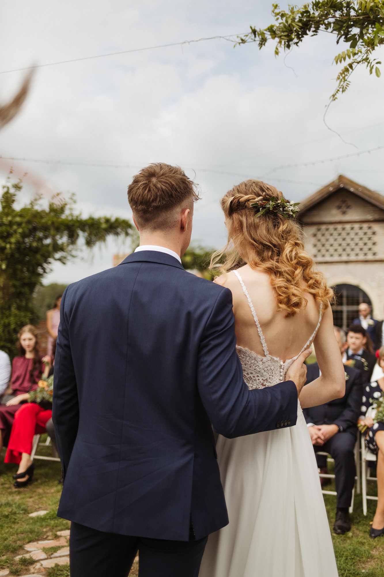 Wedding ceremony procession outside a historic brick building with decorative architecture.