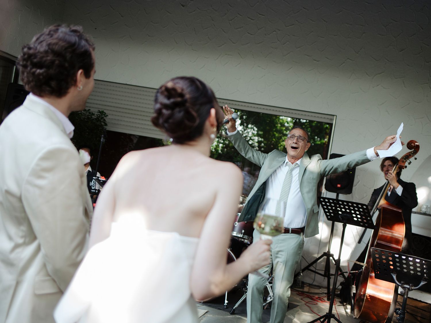 Wedding celebration in an indoor venue with people dancing and mingling under soft lights.