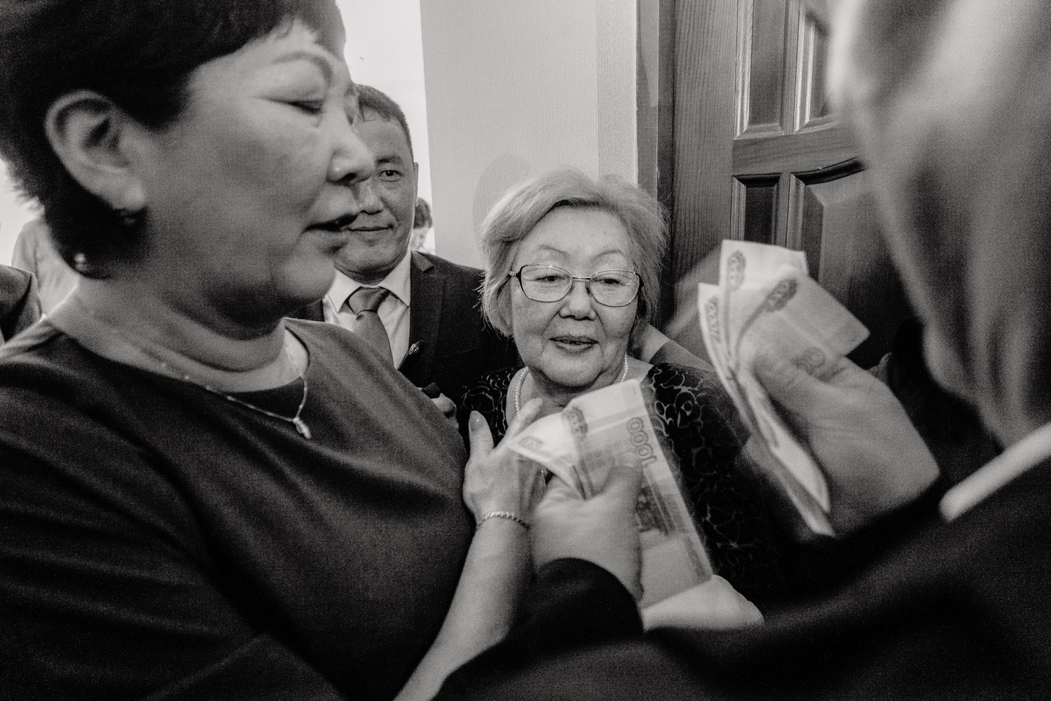 Black and white candid shots showing genuine reactions and emotions during wedding celebrations.