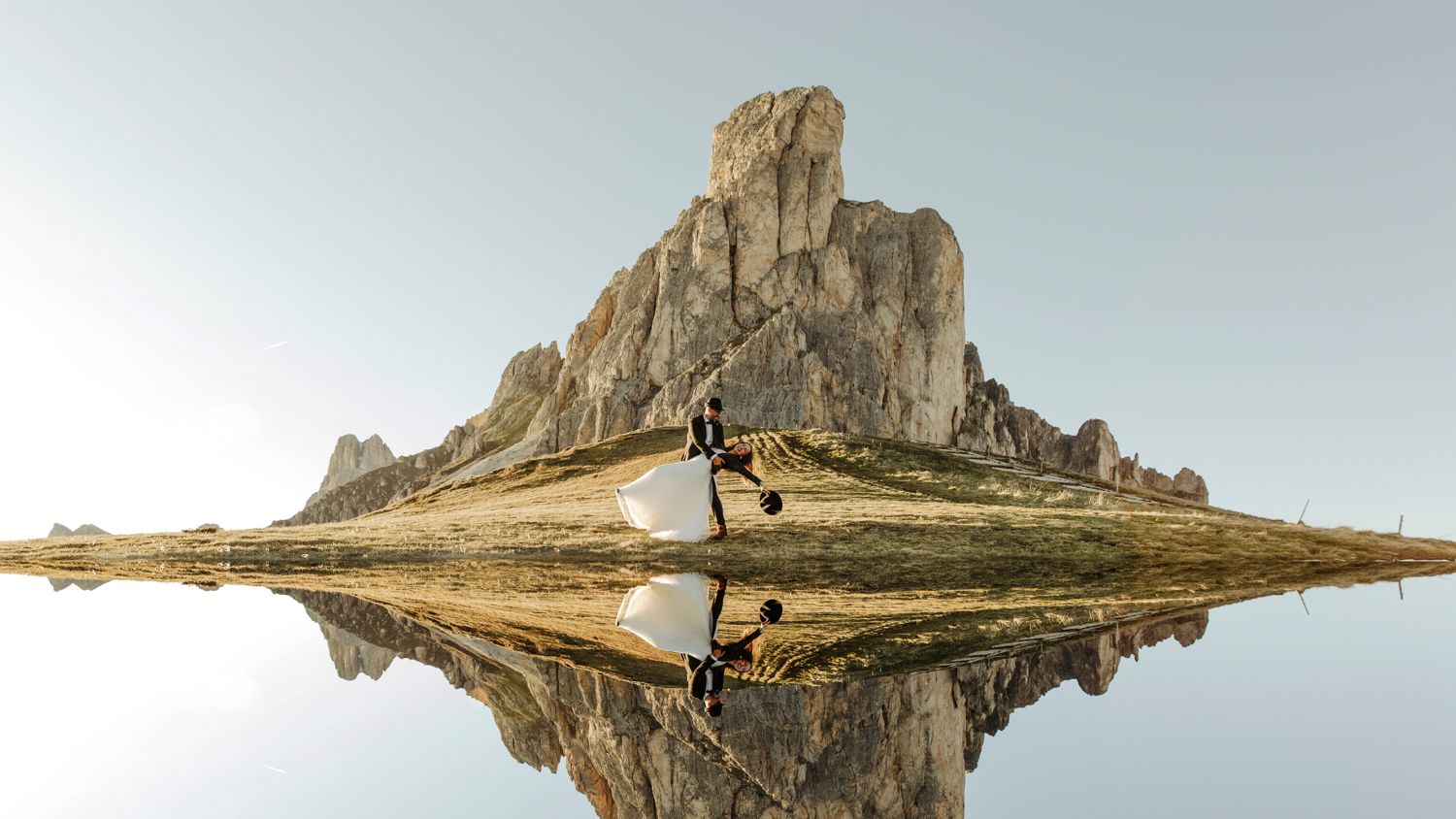 Mountain peak perfectly reflected in still water creating mirror image symmetry.