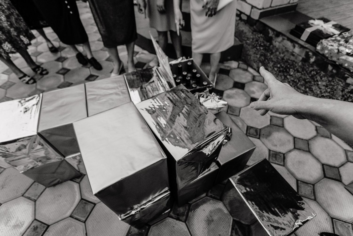 Detailed black and white photo of hands signing official documents on a patterned surface.