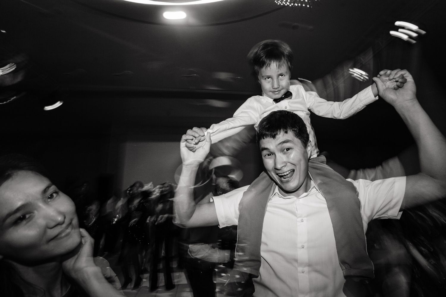 Energetic celebration captured in black and white during wedding party.