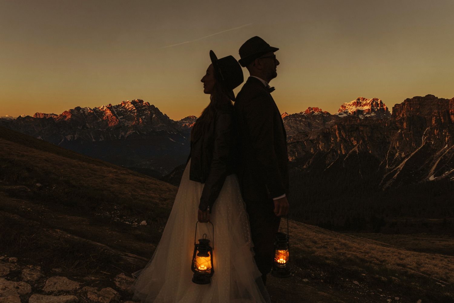 Sunset ceremony in a mountain landscape with string lights and rustic decor creating a romantic atmosphere.