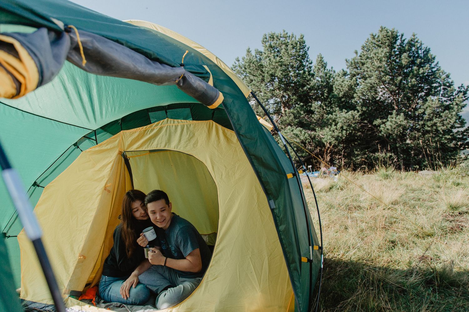 Yellow and green tents set up in grassy field for camping adventure.