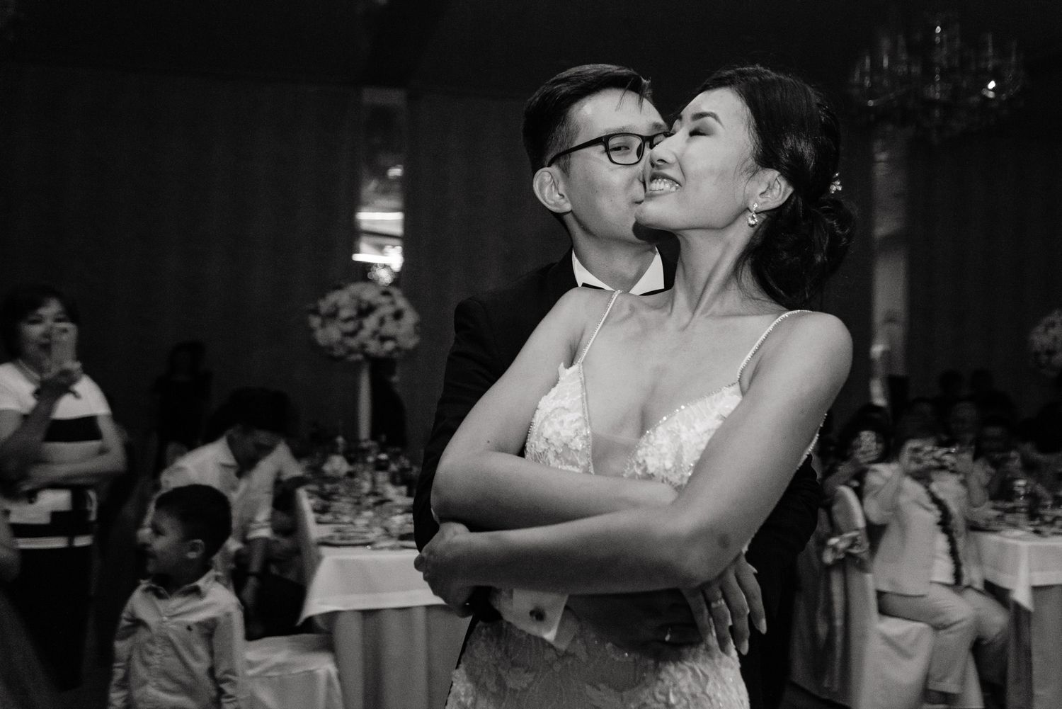 Black and white photo of romantic moment at wedding reception.