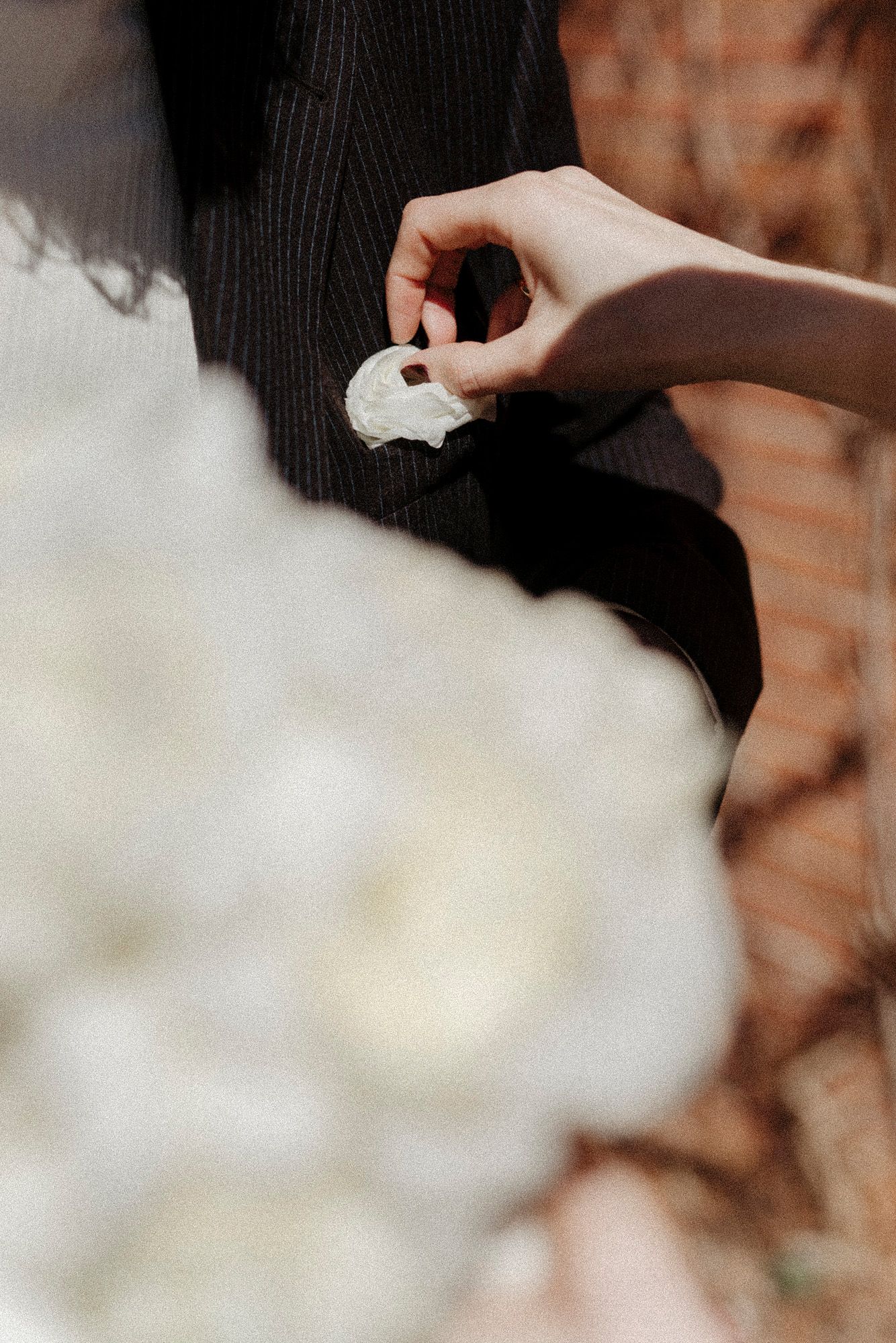Close-up detail of white fabric or clothing material against brick background.