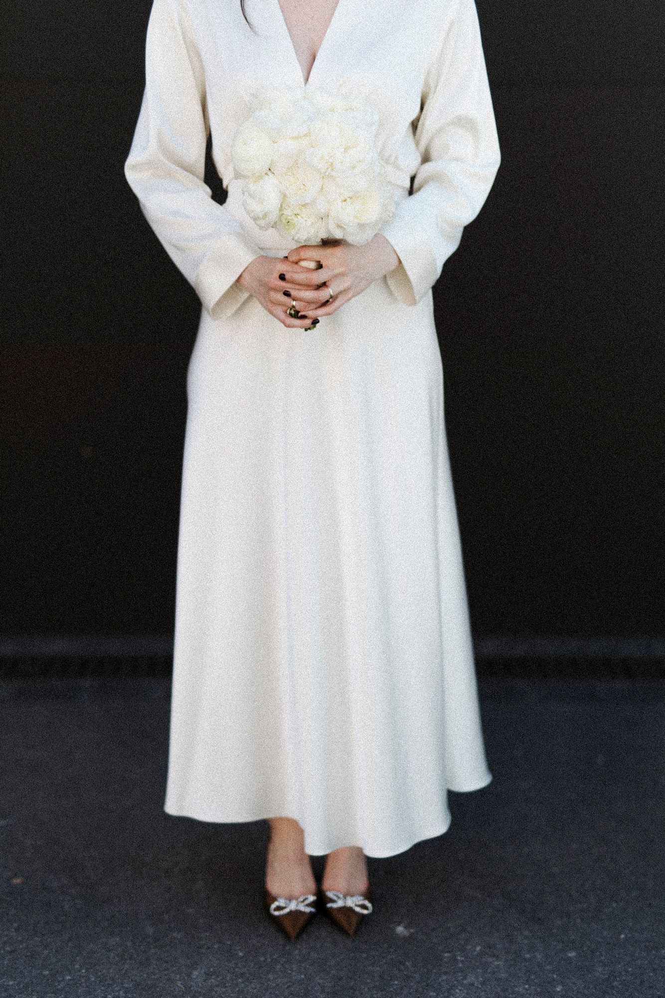Detail shots of white wedding dress and bouquet against dark background.