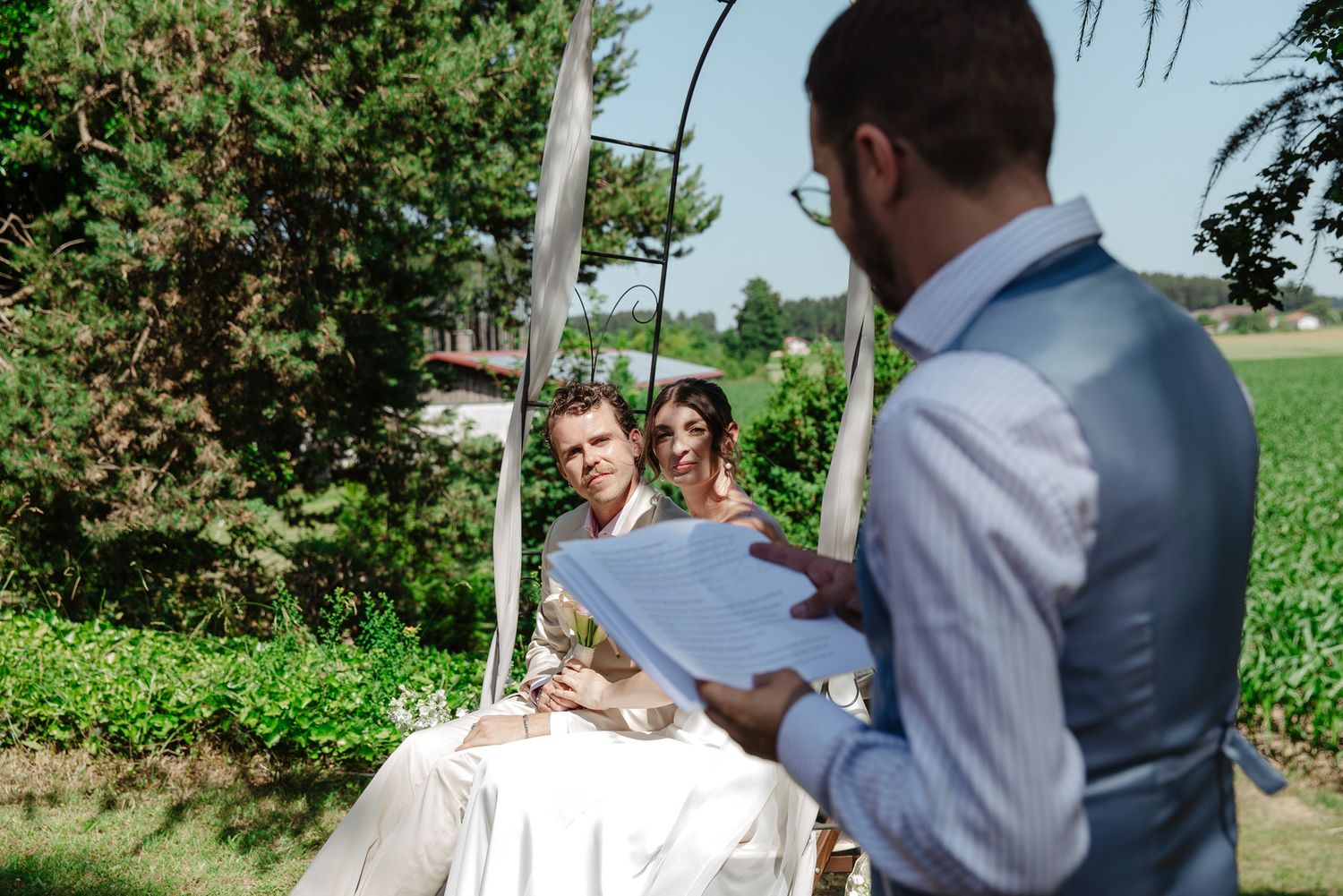 Wedding couple walking through a lush garden pathway during their celebration.