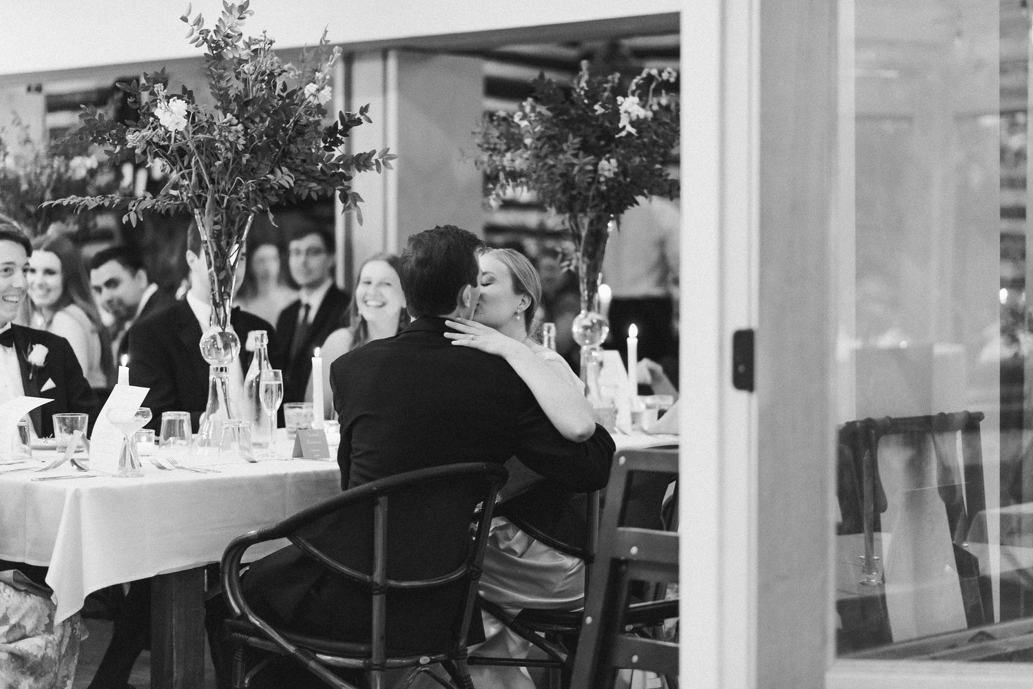 black-white-photo-of-just-married-couple-kissing-at-reception-Cedar-Knolls
