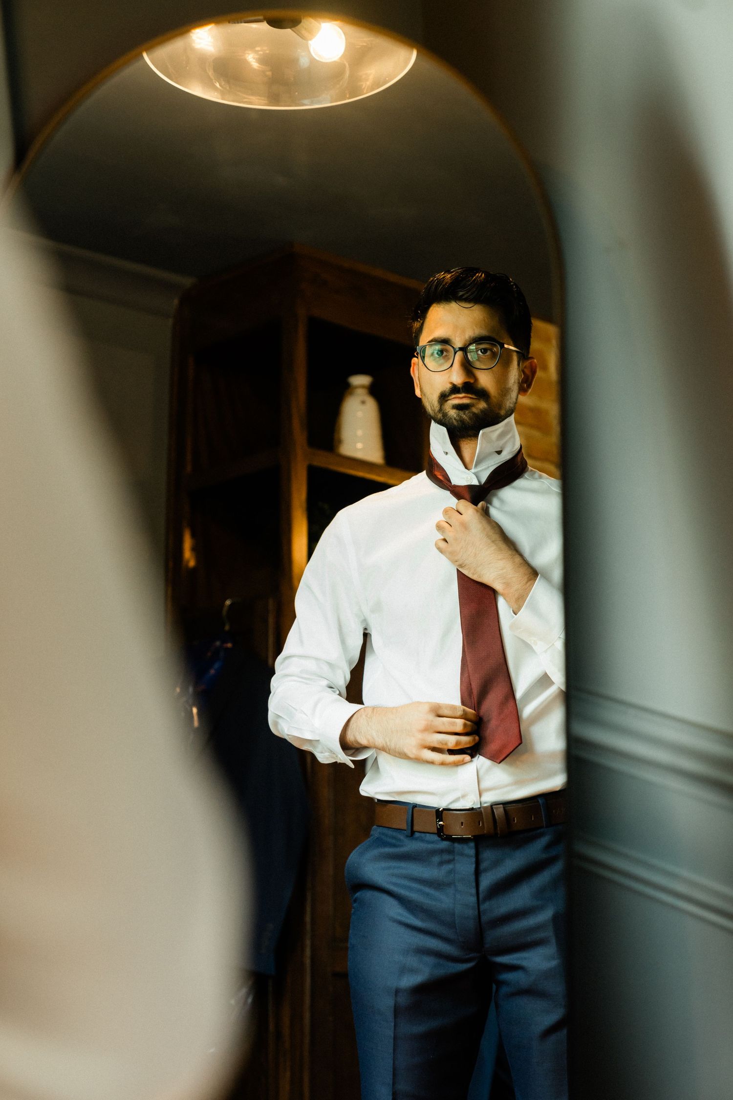 groom tying his neck tie