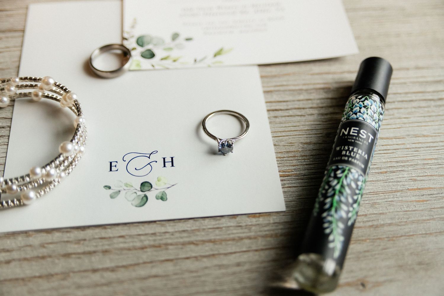 A photo of the brides details: perfume, ring, bracelet, stationary.