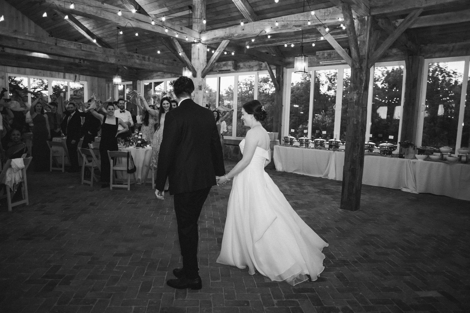 black and white photo of the bride and groom entering reception space at The Old Farm Winery