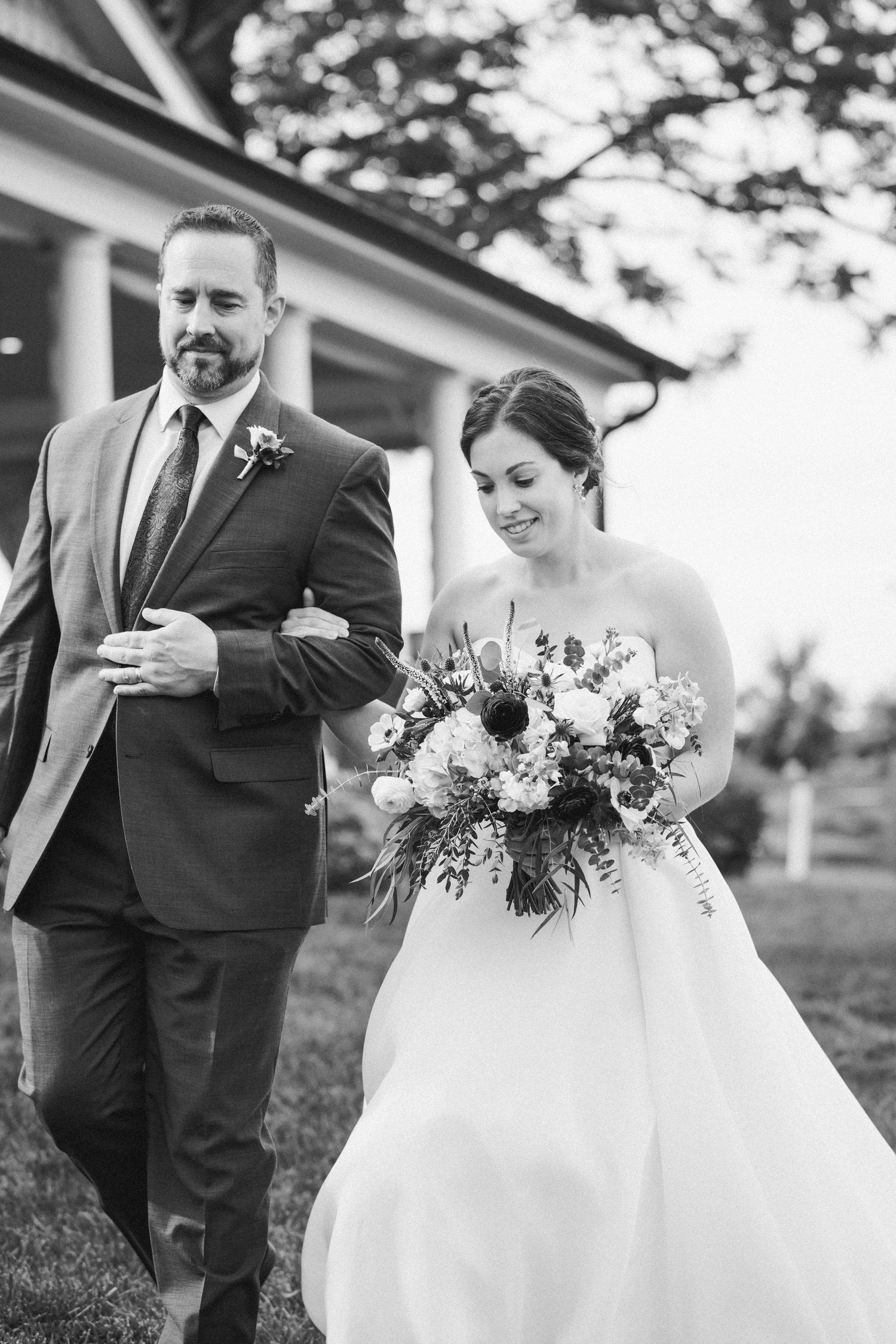 black and white photo of the bride coming down the aisle