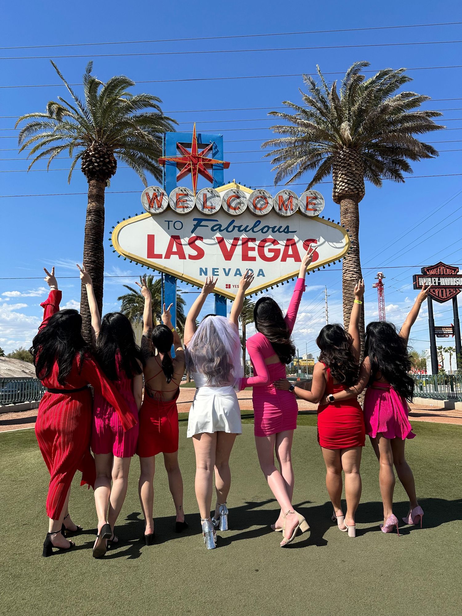 Group celebrating in front of the iconic Las Vegas welcome sign.