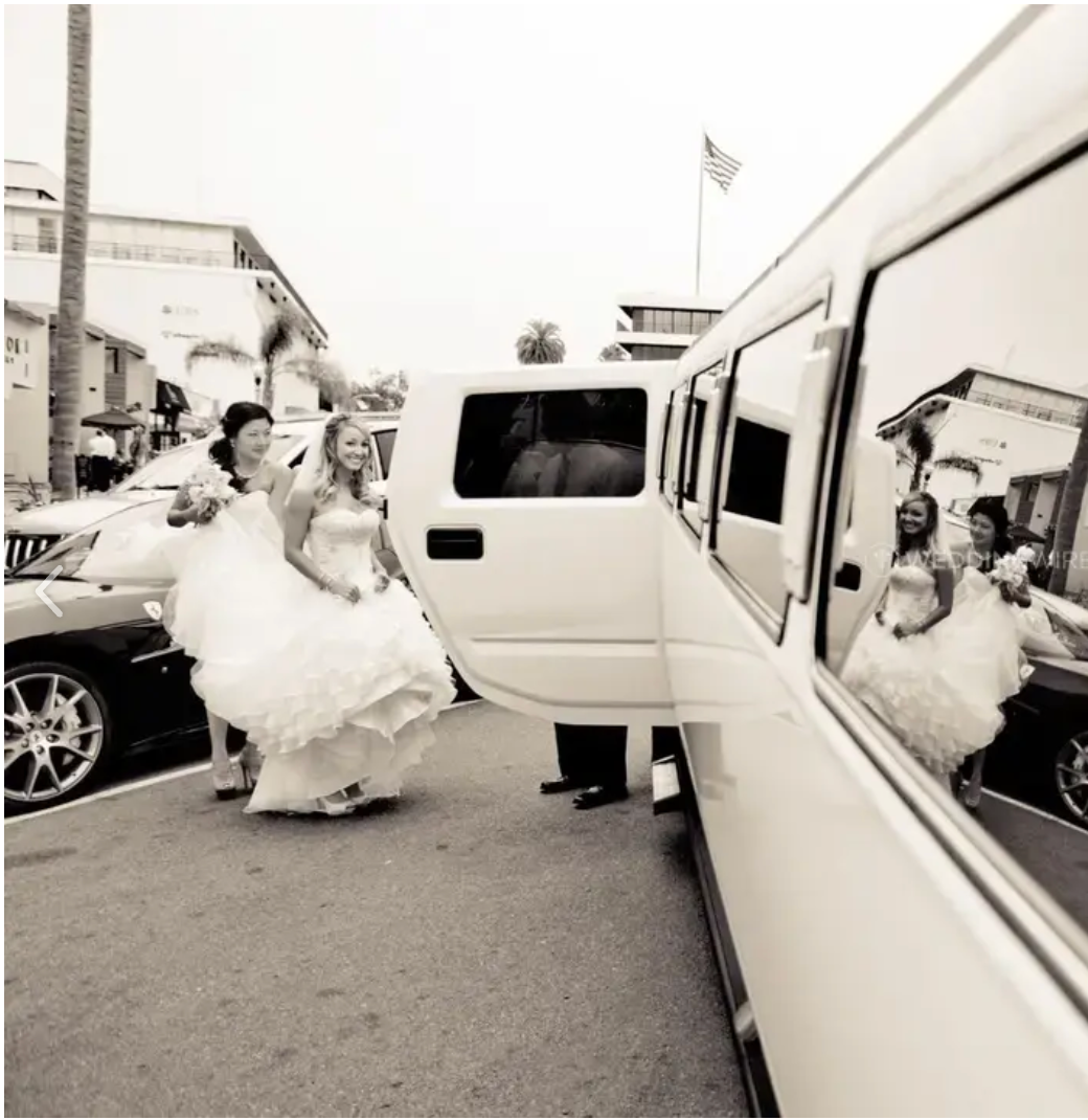 Black and white photo of wedding party getting into a limousine.