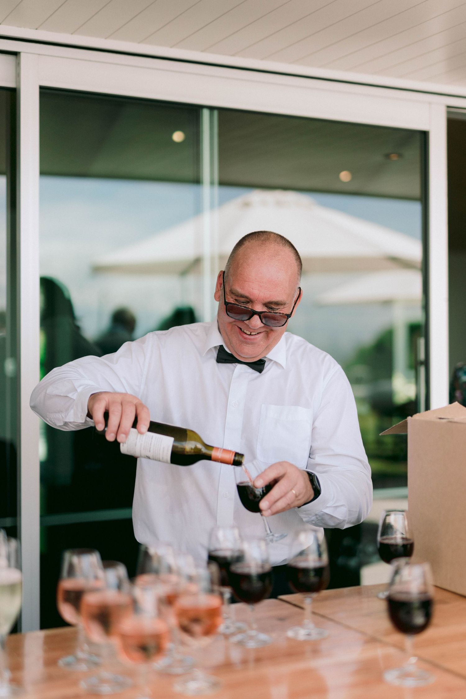 A sequence showing someone pouring wine into multiple glasses at an elegant event.