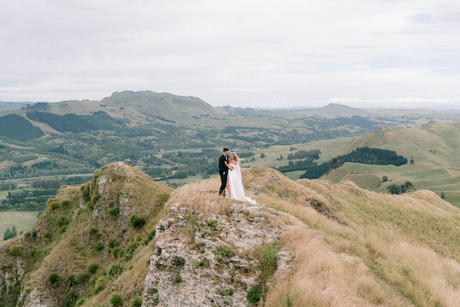 Sweeping mountaintop vista with dramatic cliffs and green valleys below.