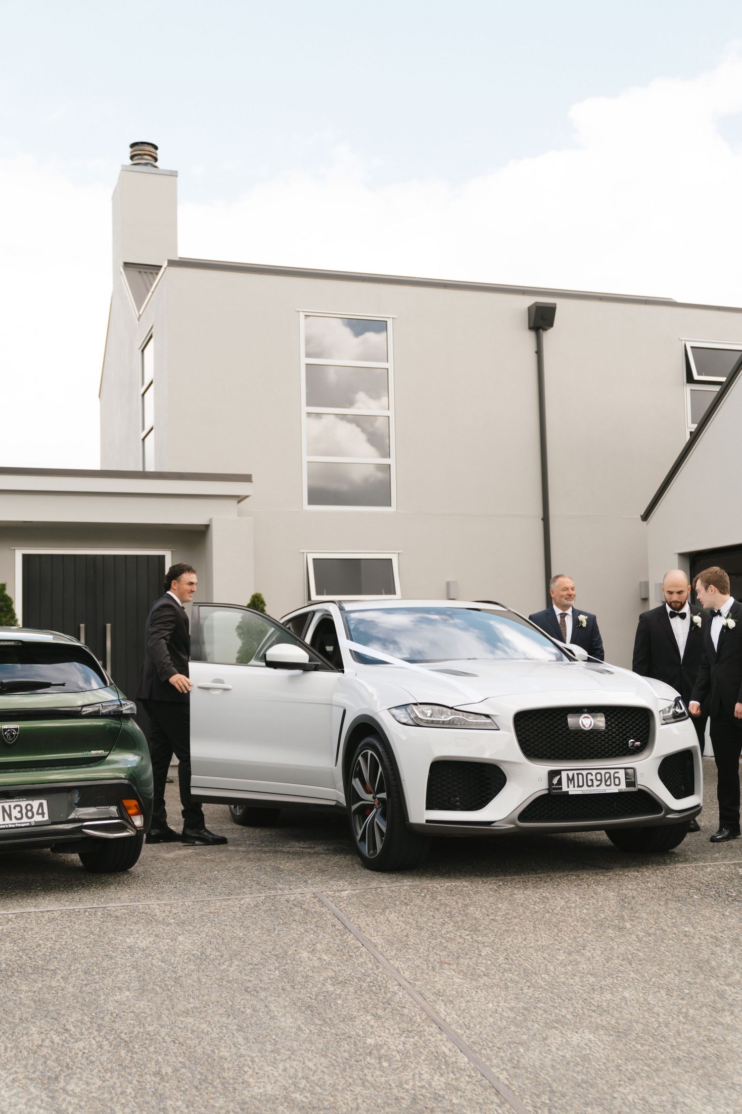 Row of luxury Jaguar vehicles parked outside modern white buildings.