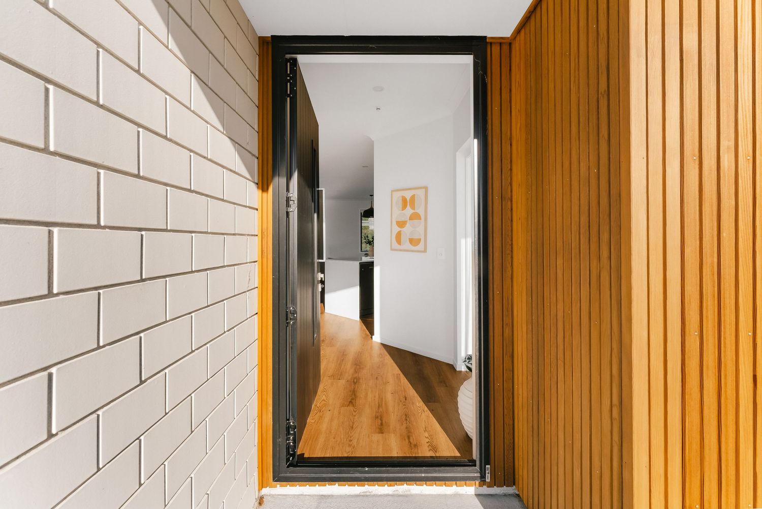 Contemporary hallway featuring white brick walls and warm wooden paneling details.