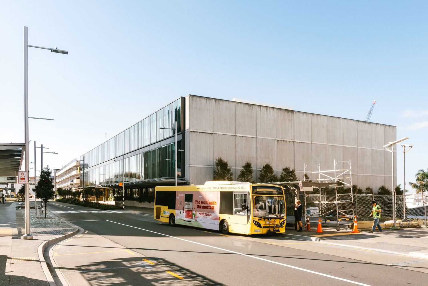Industrial warehouse building with exterior loading docks, concrete walls and security lighting under blue sky.