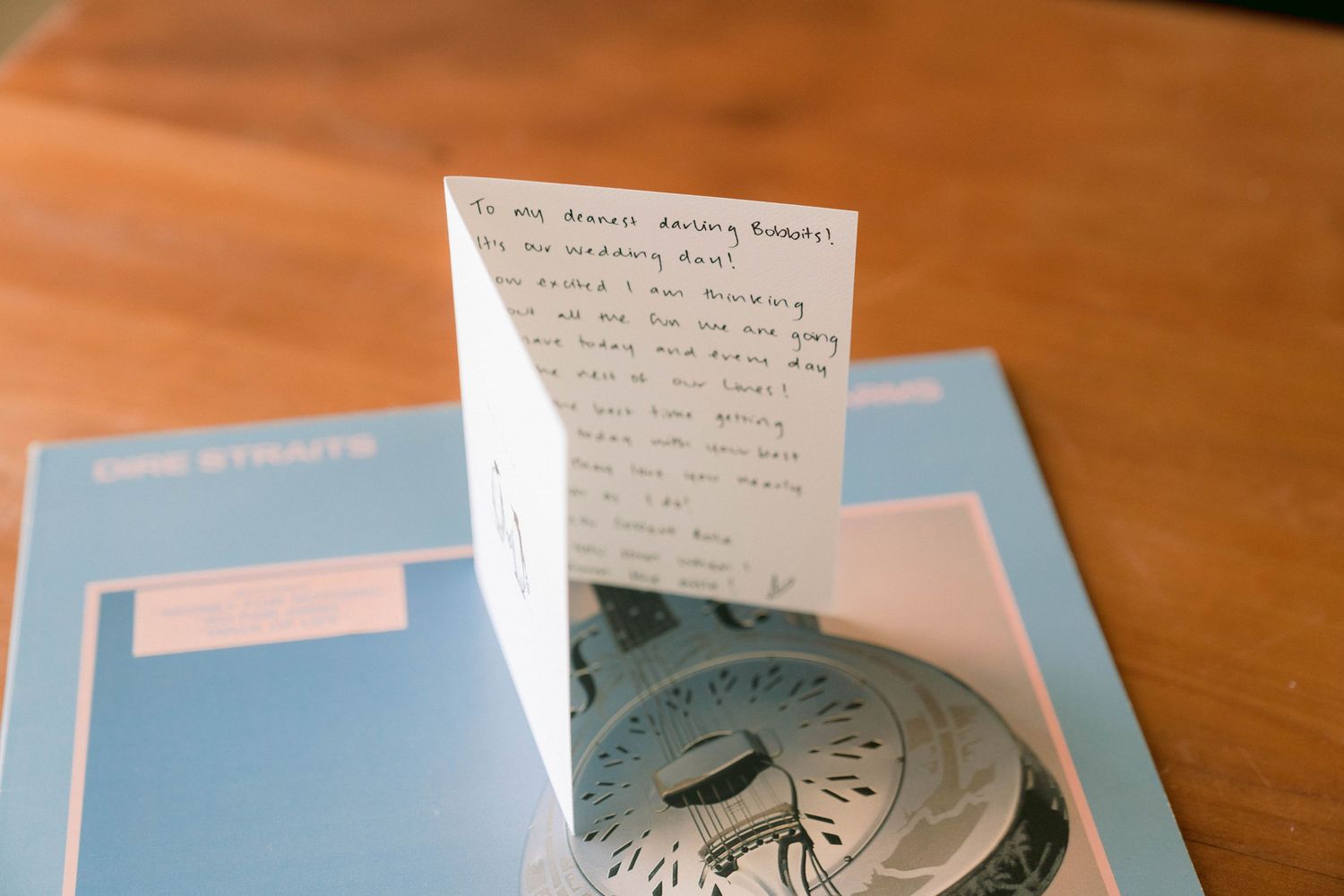 Handwritten note beside a vintage compass on light blue papers.