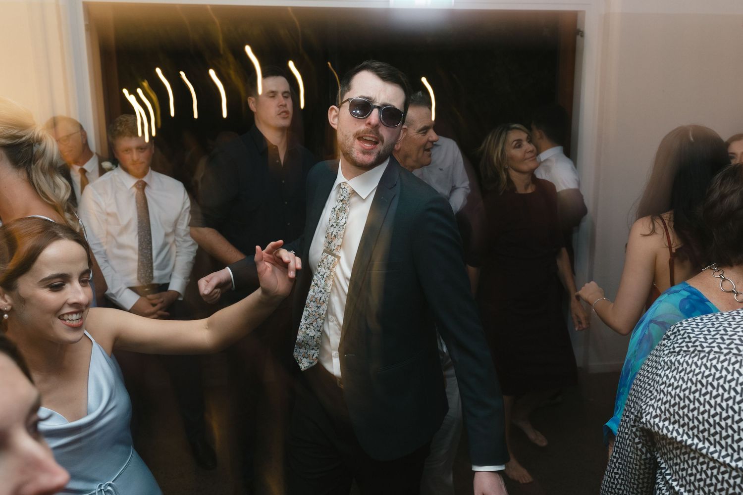 Wedding reception dance party with guests enjoying celebration indoors.