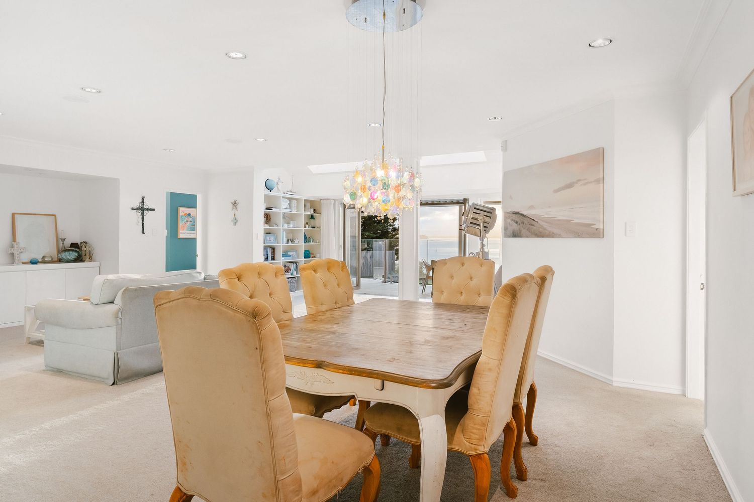 Elegant dining area with cream upholstered chairs and crystal chandelier.