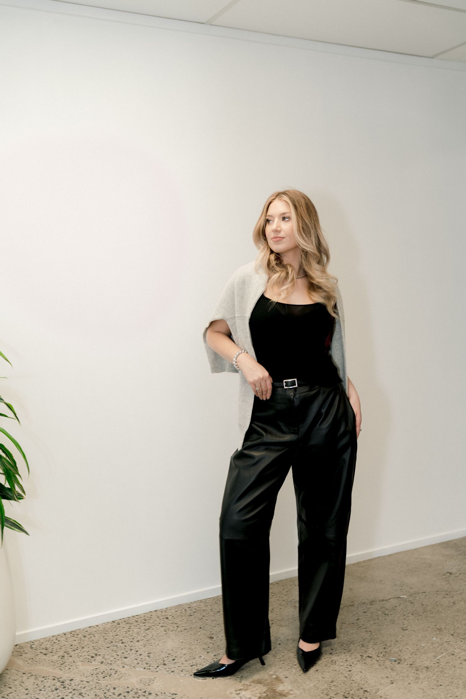 Modern fashion photo series showing different poses and angles in a monochromatic black outfit.