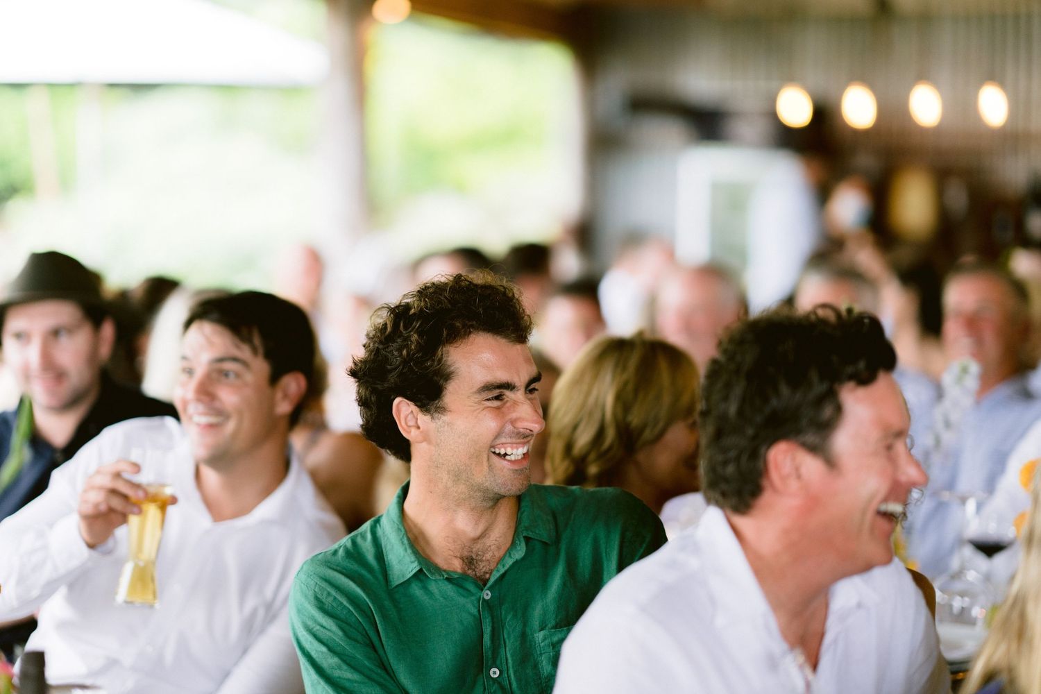 Wedding guests laughing and enjoying themselves during reception celebrations.
