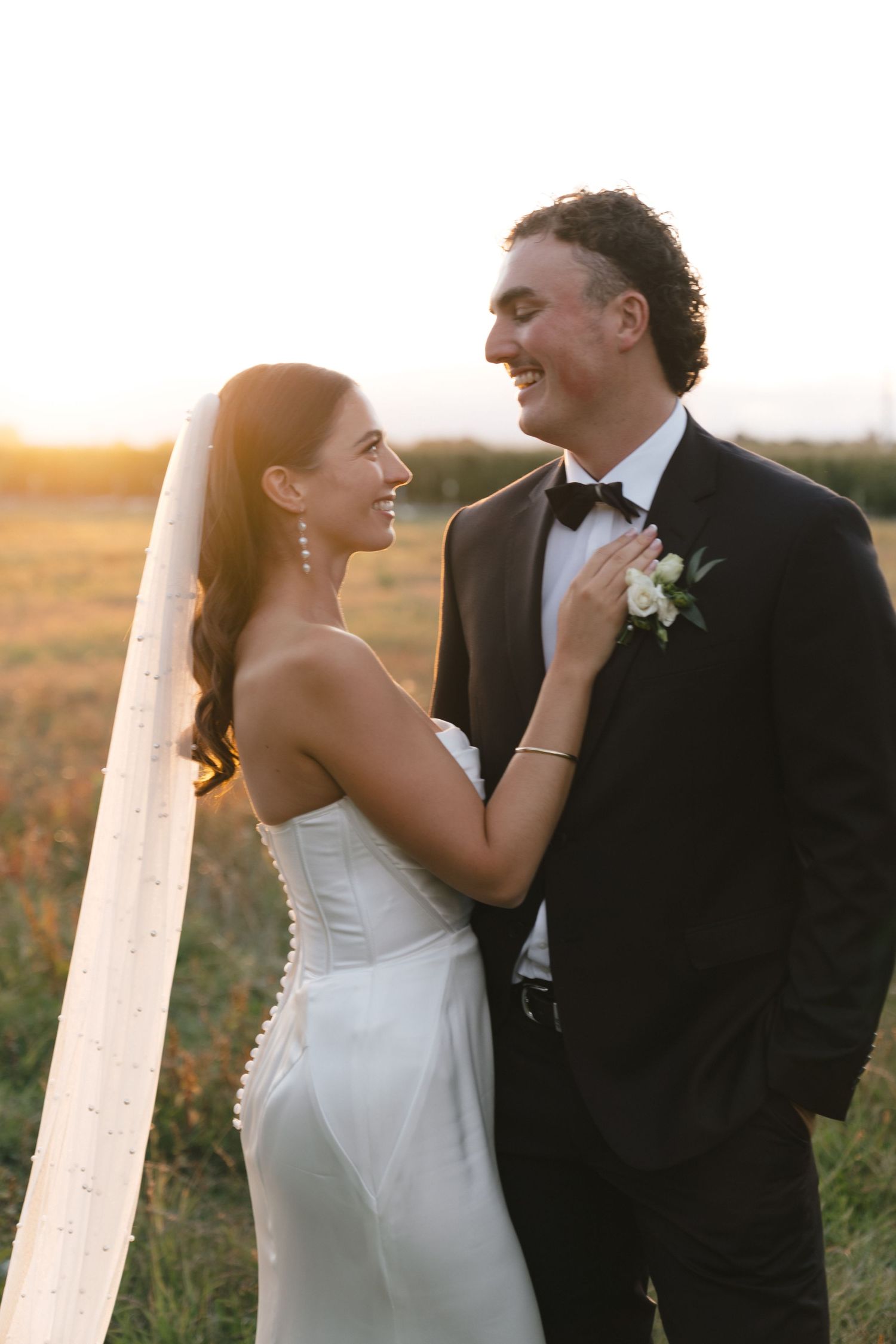 Bride and groom share romantic moments against a golden sunset backdrop.