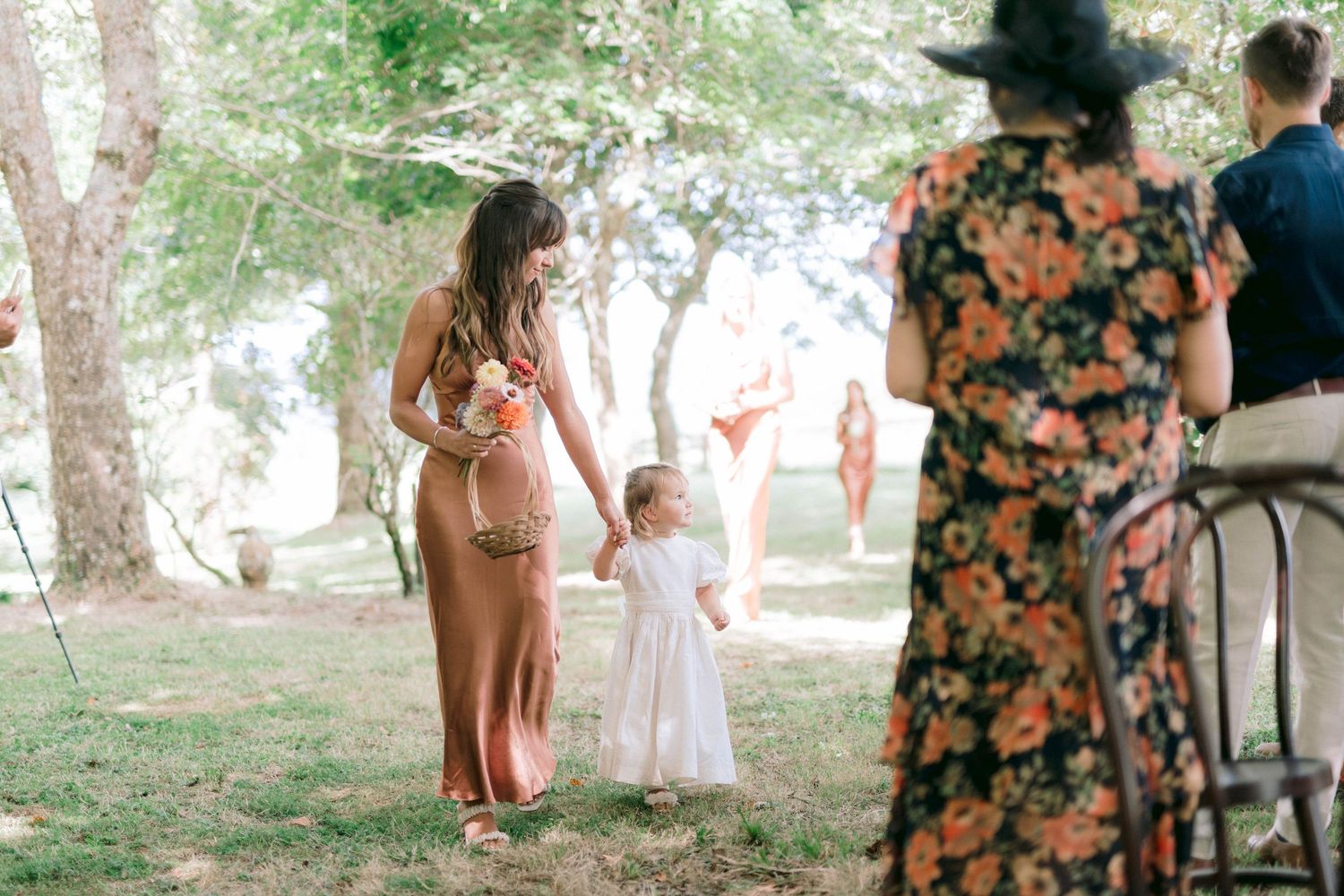Guests gather under shady trees at an outdoor summer celebration.
