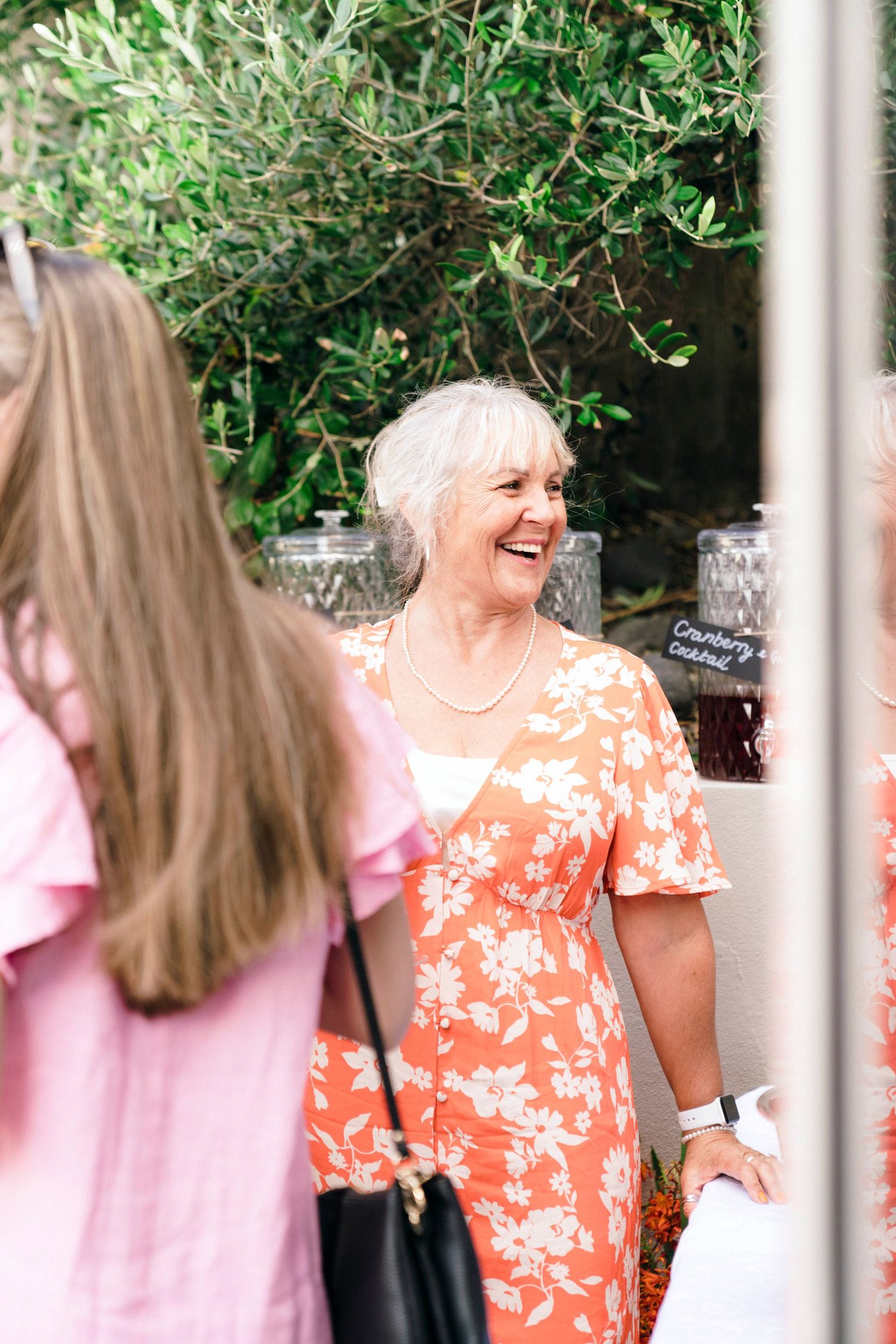 A lively outdoor gathering with colorful summer dresses and natural greenery.