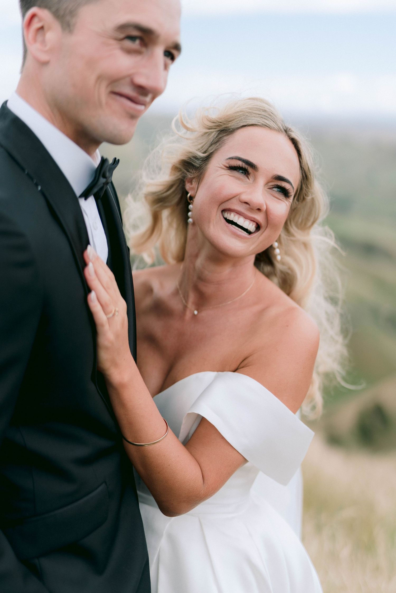 A joyful moment between newlyweds captured against a mountainous landscape.