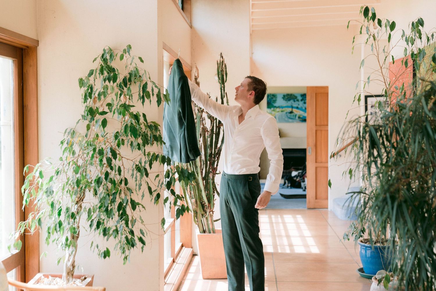 Interior hallway with bamboo plants and natural light streaming through large windows.