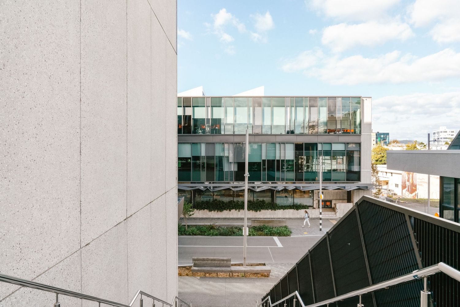 Modern concrete building with large windows and geometric architecture photographed from multiple angles.