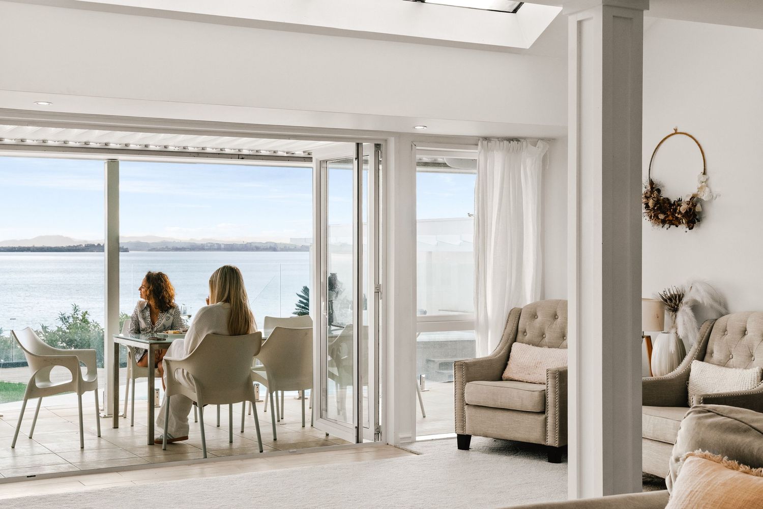 Bright dining area with waterfront views through floor-to-ceiling windows.