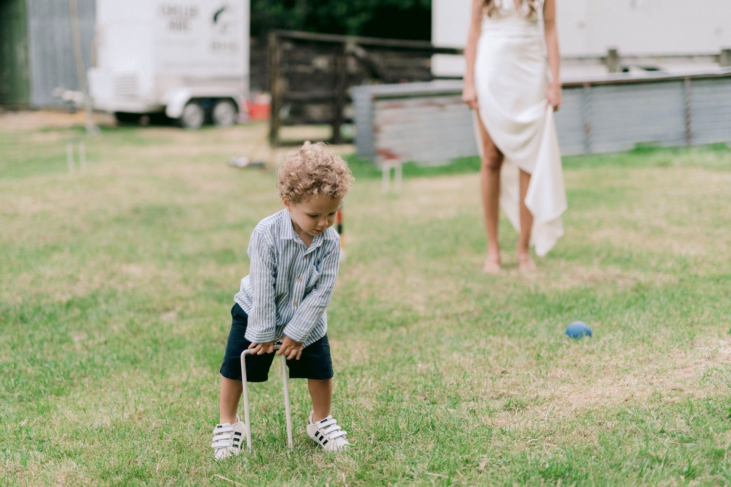 Children playing on grassy lawn during daytime outdoor event.