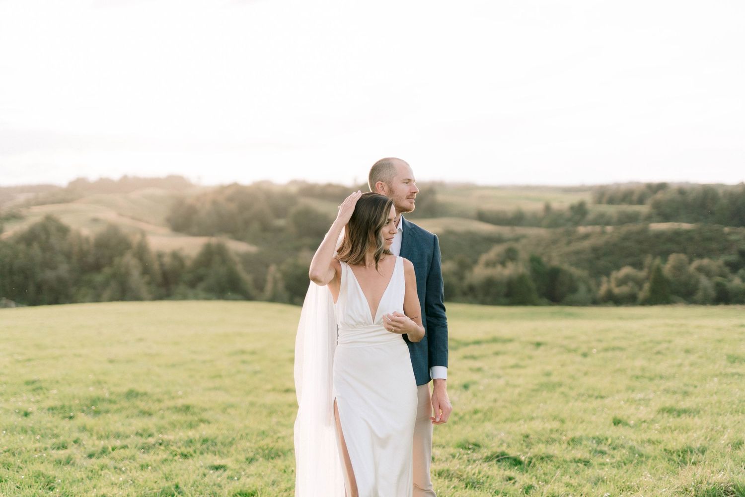 Romantic sunset portrait session in a rolling meadow with golden light.