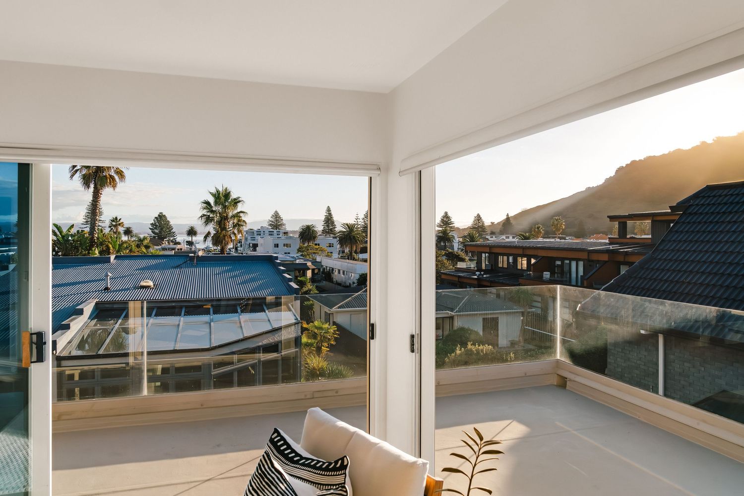 Contemporary covered deck space with expansive windows showcasing coastal neighborhood views.