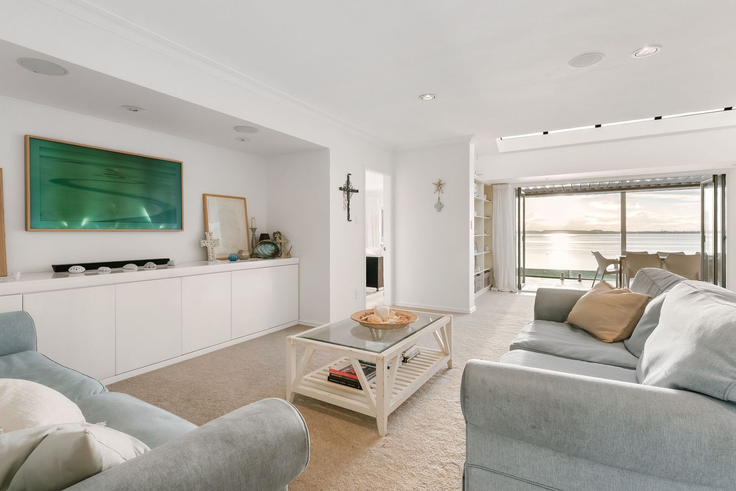 Minimalist living room with gray sectional sofa and bright white walls.