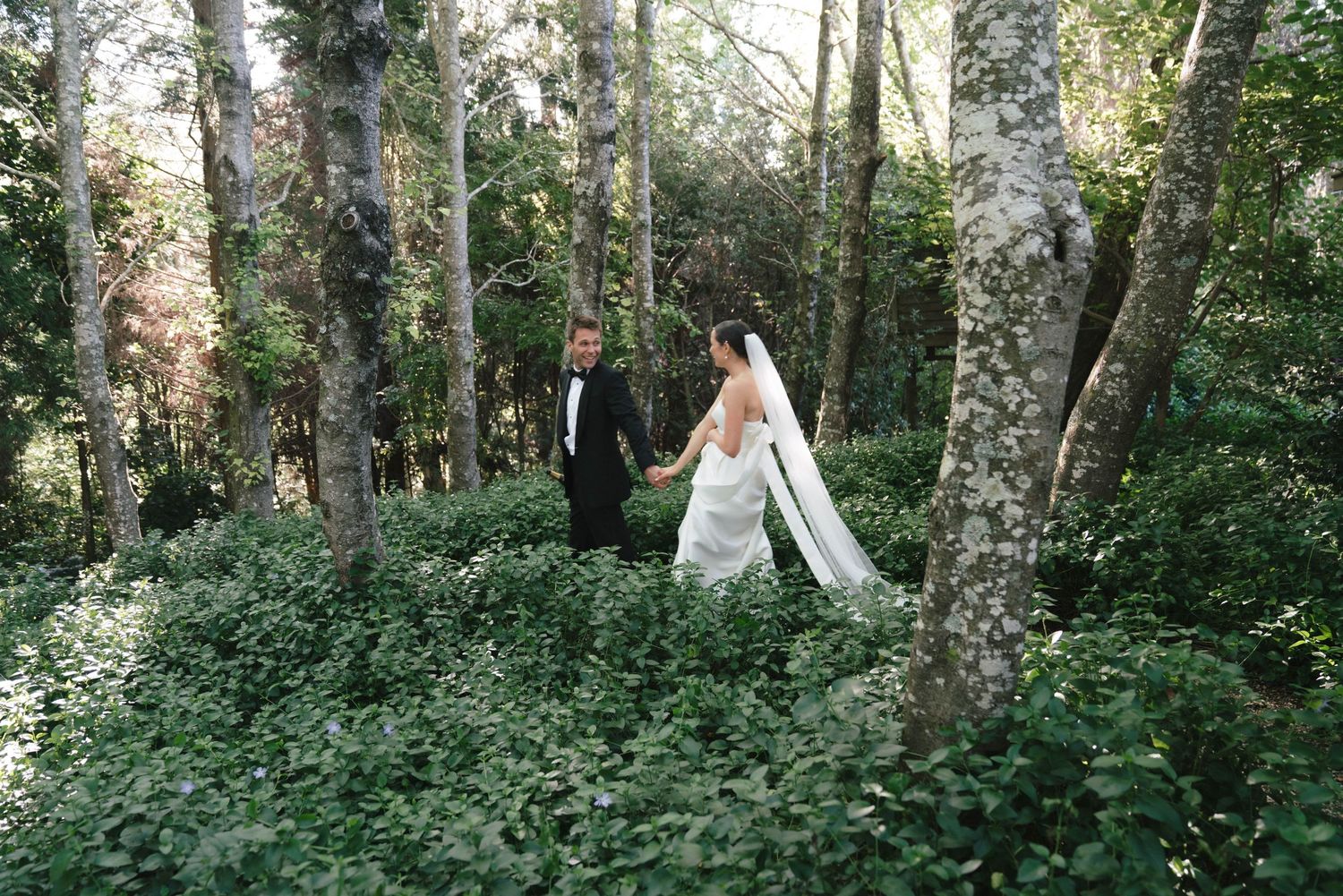 A dreamy outdoor forest setting with teepees and natural greenery creates a magical woodland atmosphere for an event.