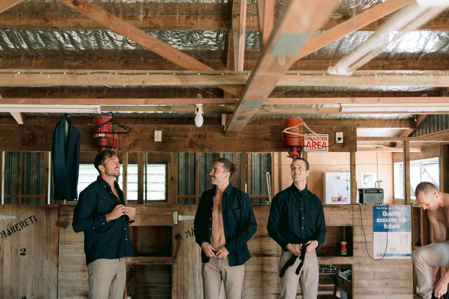 People gather in rustic wooden cabin interior with exposed beams and red hanging lamps.