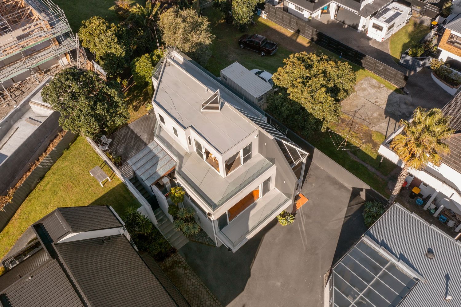 Aerial view of modern residential neighborhood with white houses and landscaped yards.