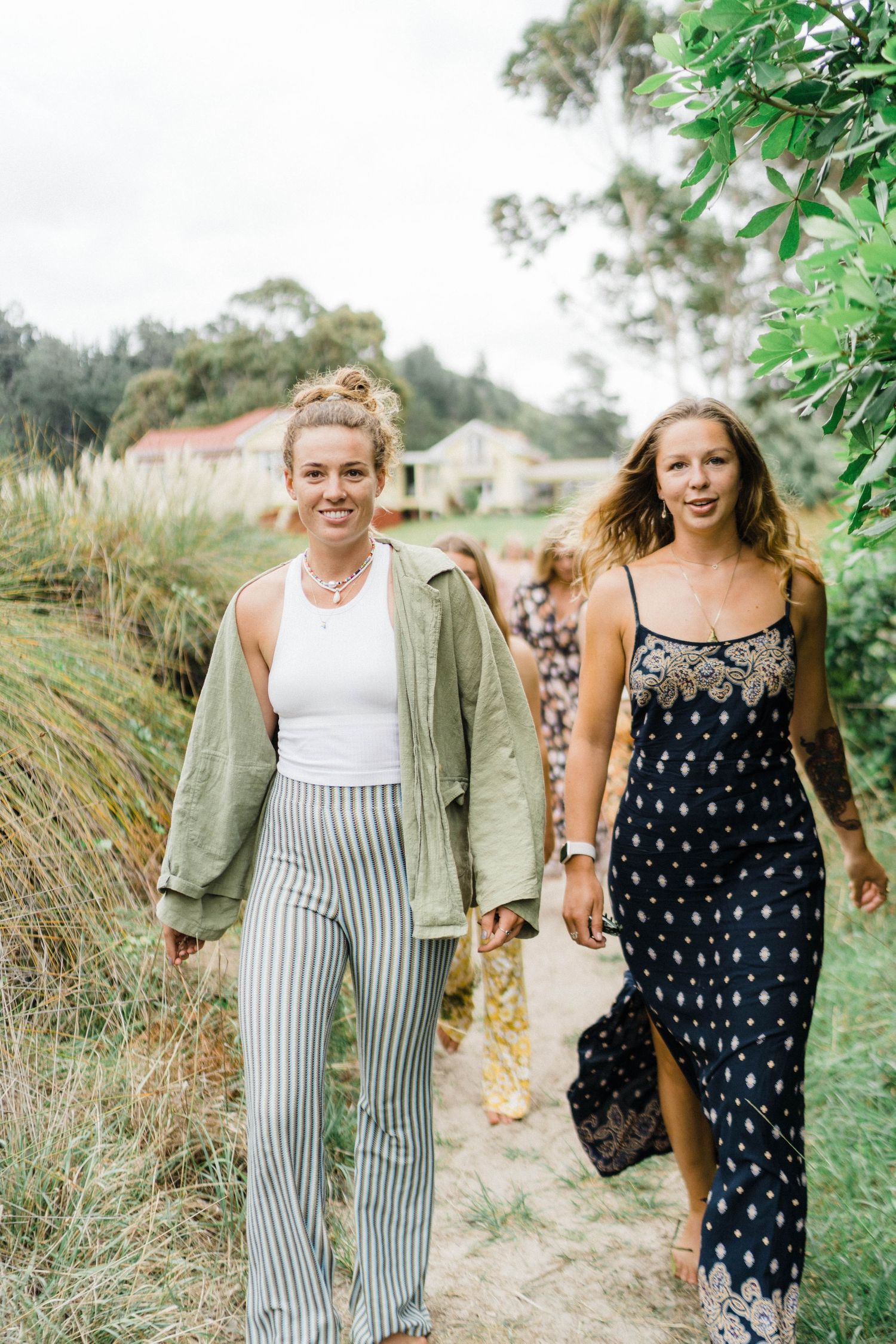 Two people walking along a countryside path wearing casual summer outfits.