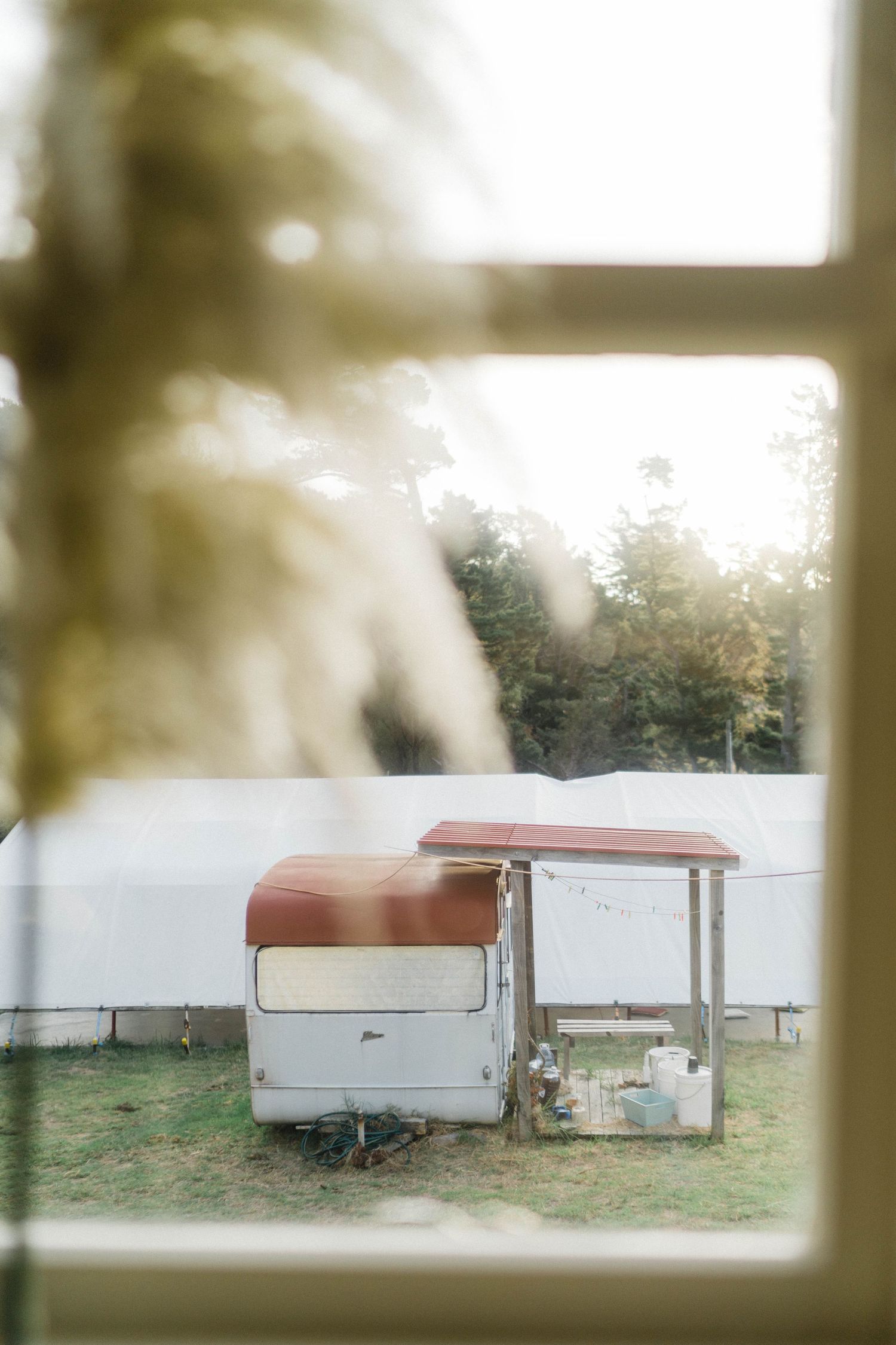 Vintage white trailer viewed through a window with dreamy, soft focus edges.