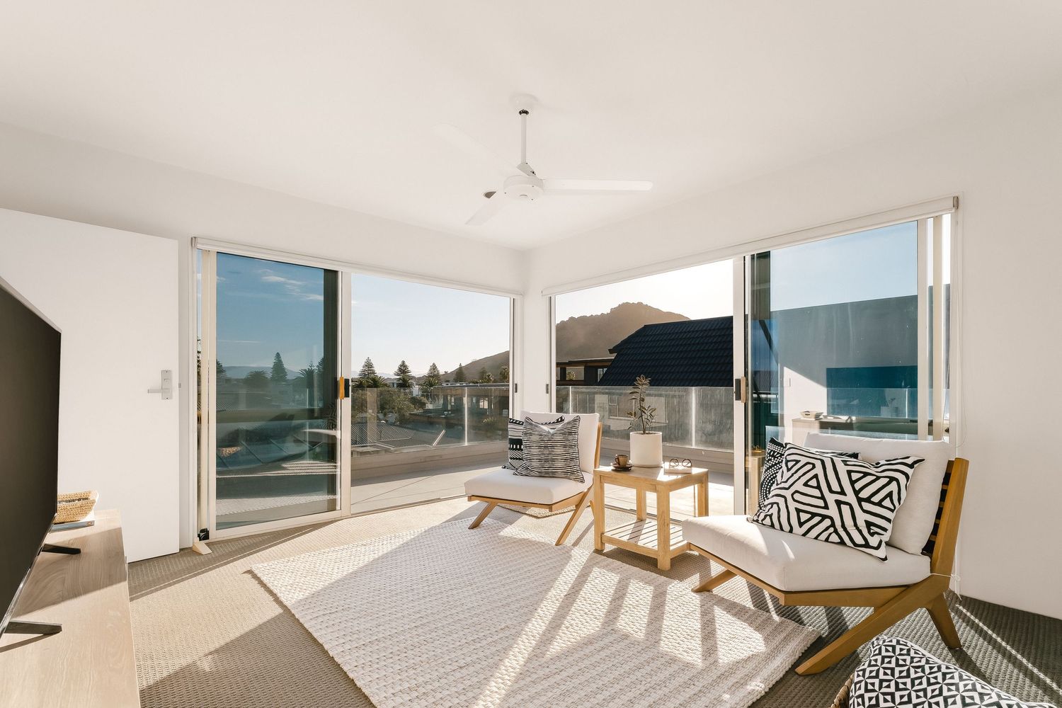 Light-filled coastal home interior with panoramic windows and minimalist design elements.