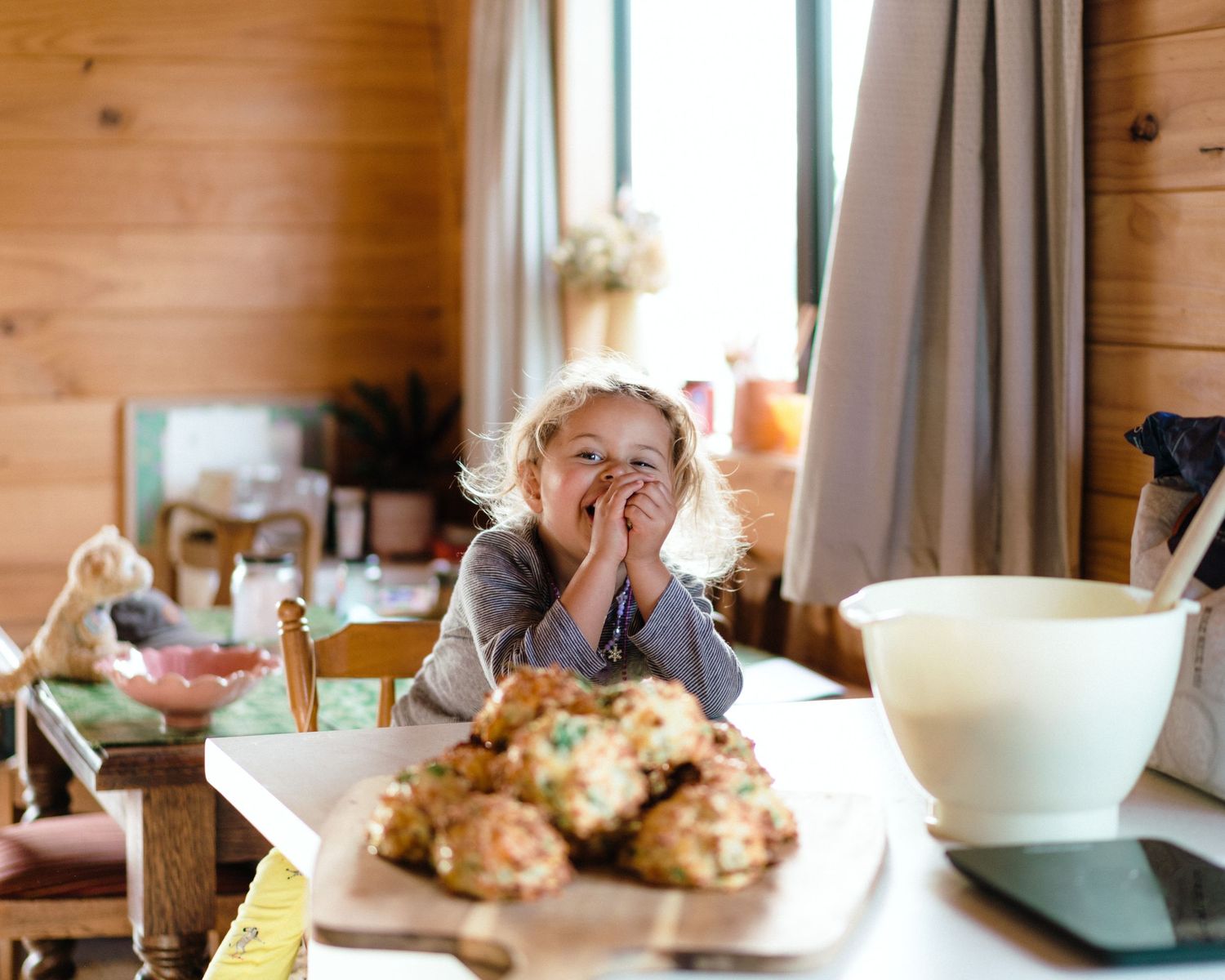A cheerful morning baking scene in a cabin kitchen with fresh-baked goods on the counter.