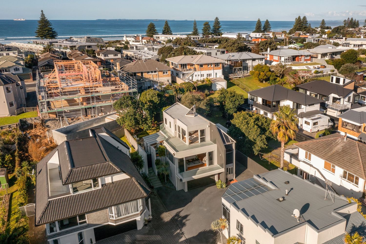 Aerial view of beachside community with modern homes and ocean vista.